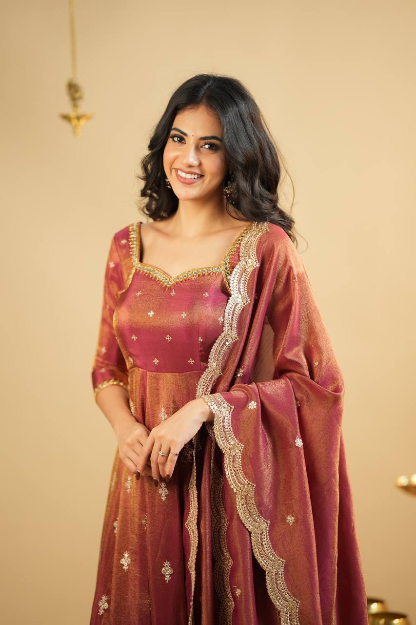 "Smiling woman in rust orange Anarkali dress with traditional golden embroidery and flared hem – perfect festive and ethnic wear for weddings or parties."

"Rust orange embroidered Anarkali gown for women with golden motifs and traditional festive design"

"Elegant ethnic Anarkali suit in rust orange with intricate zari embroidery – festive Indian wear for women"

"Rust orange Anarkali gown with gold embroidery for festive occasions"




